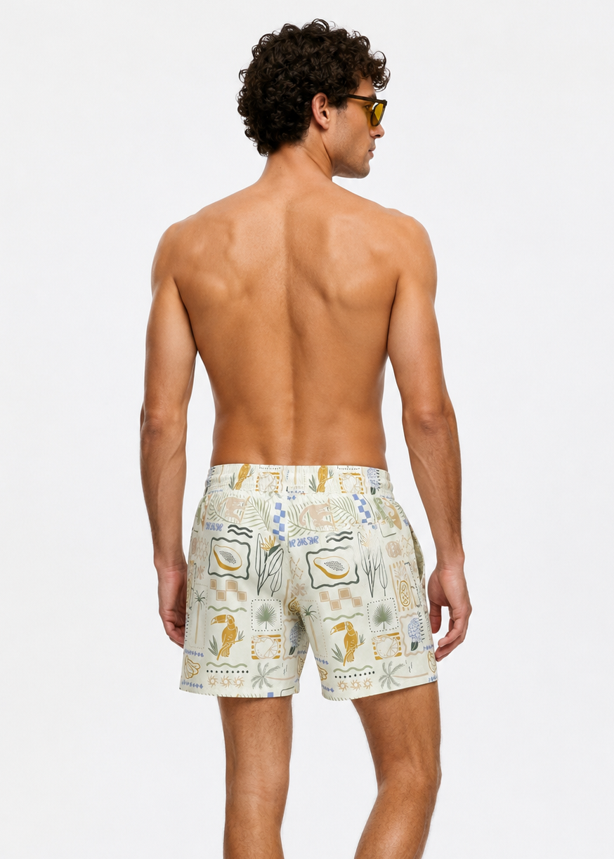 Man wearing patterned swim shorts on a white background