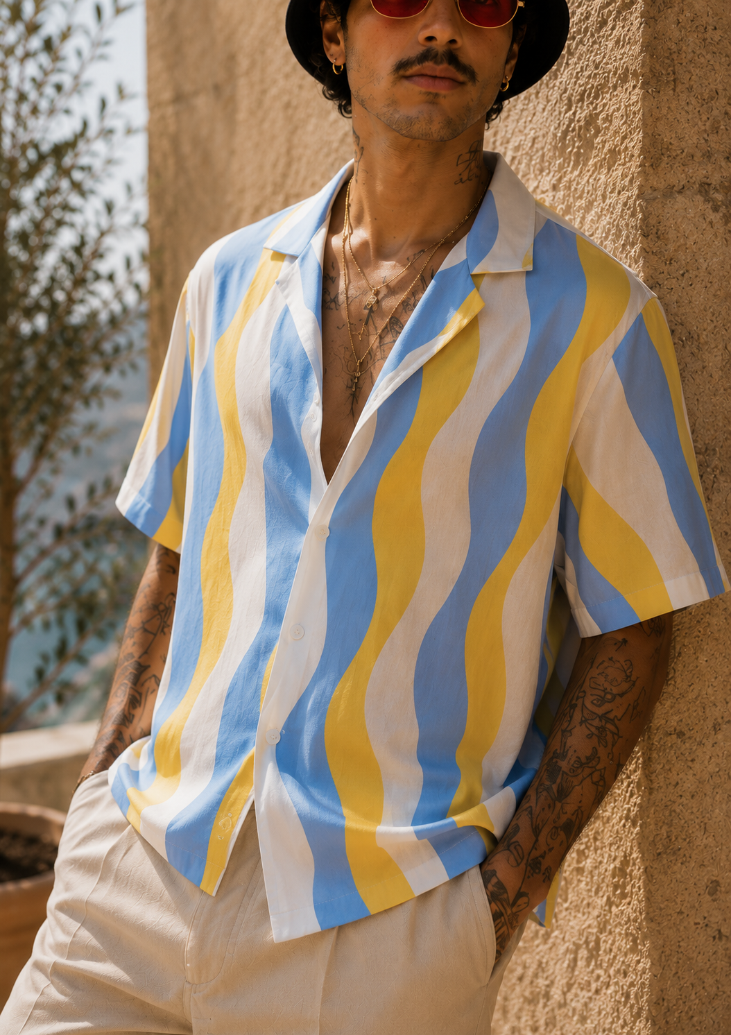 Man wearing a colorful striped shirt against a textured wall.