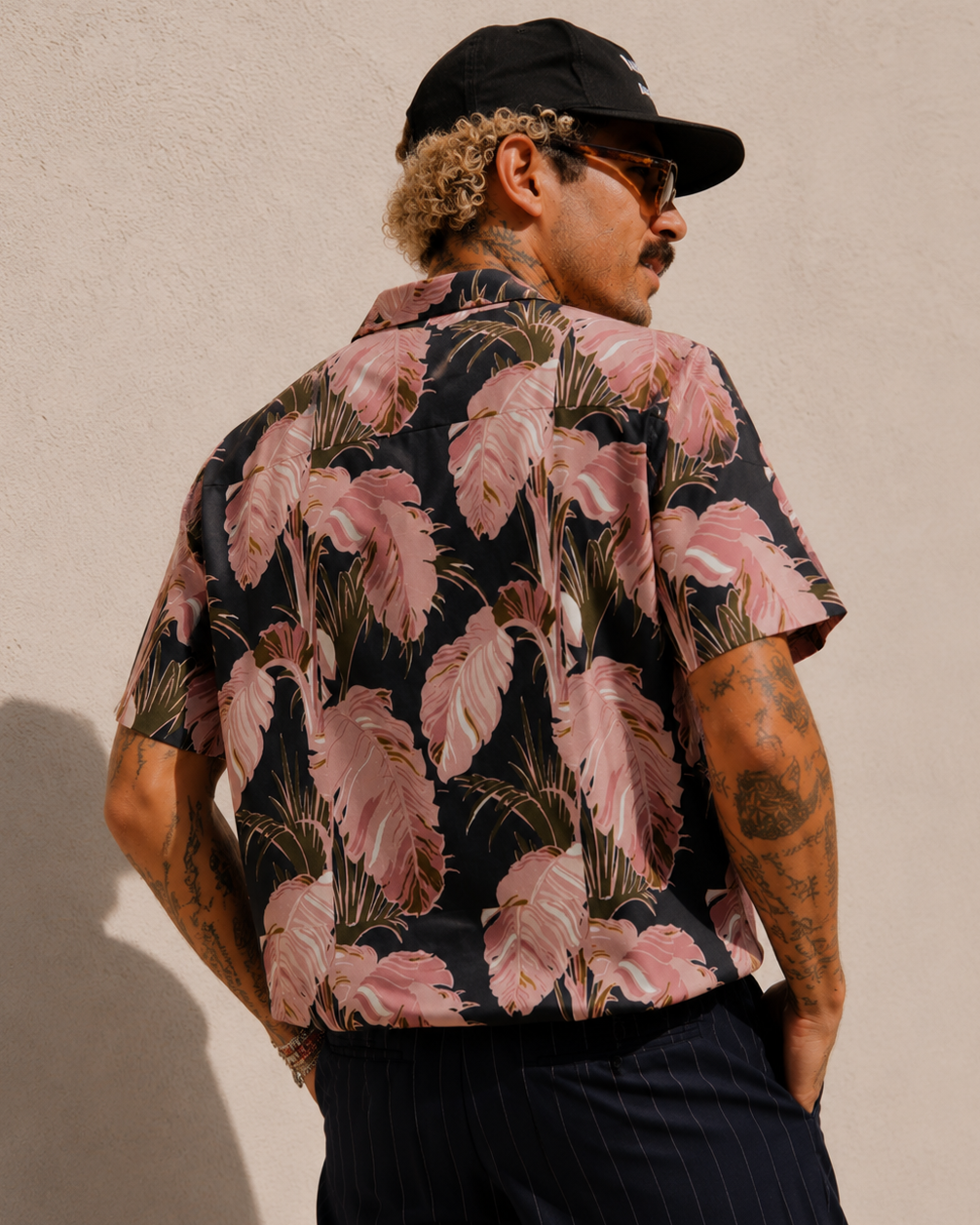 Man wearing a floral patterned shirt with a beige background