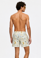 Man wearing patterned swim shorts on a white background