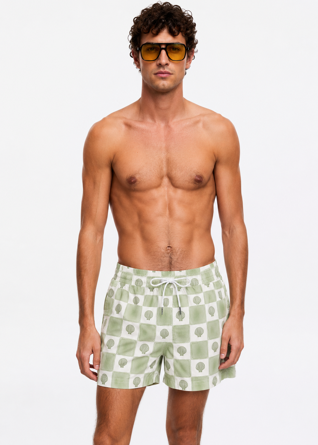 Man wearing green checkered swim shorts and sunglasses on a white background