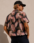 Man wearing a floral patterned shirt with a beige background
